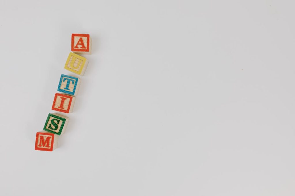 Wooden blocks spelling AUTISM on a white background emphasizing awareness.